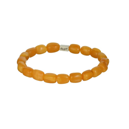 Orange beaded bracelet with a smooth texture and silver ’flut’ tag