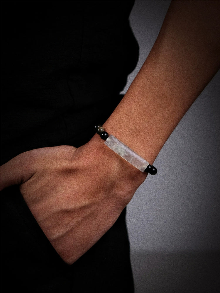 White beaded bracelet with black accents and silver clasp